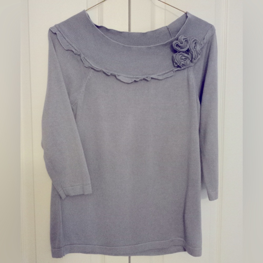 Cowl sweater with ruff edging and rosettes.